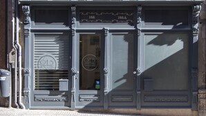 A building facade with ornate architectural details, including decorative moldings and a sign with the number 166. - Oporto Local Studios (Porto)