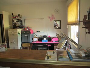 A small office with a desk, filing cabinets, a whiteboard, and a window with blinds. - Bad Axe Motel (Bad Axe)