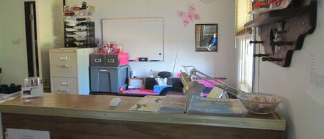 A small office with a desk, filing cabinets, a whiteboard, and a clock on the wall.