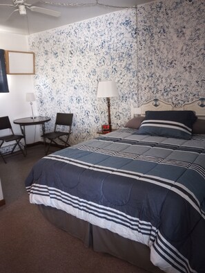 Un dormitorio con una cama, un escritorio y una silla.