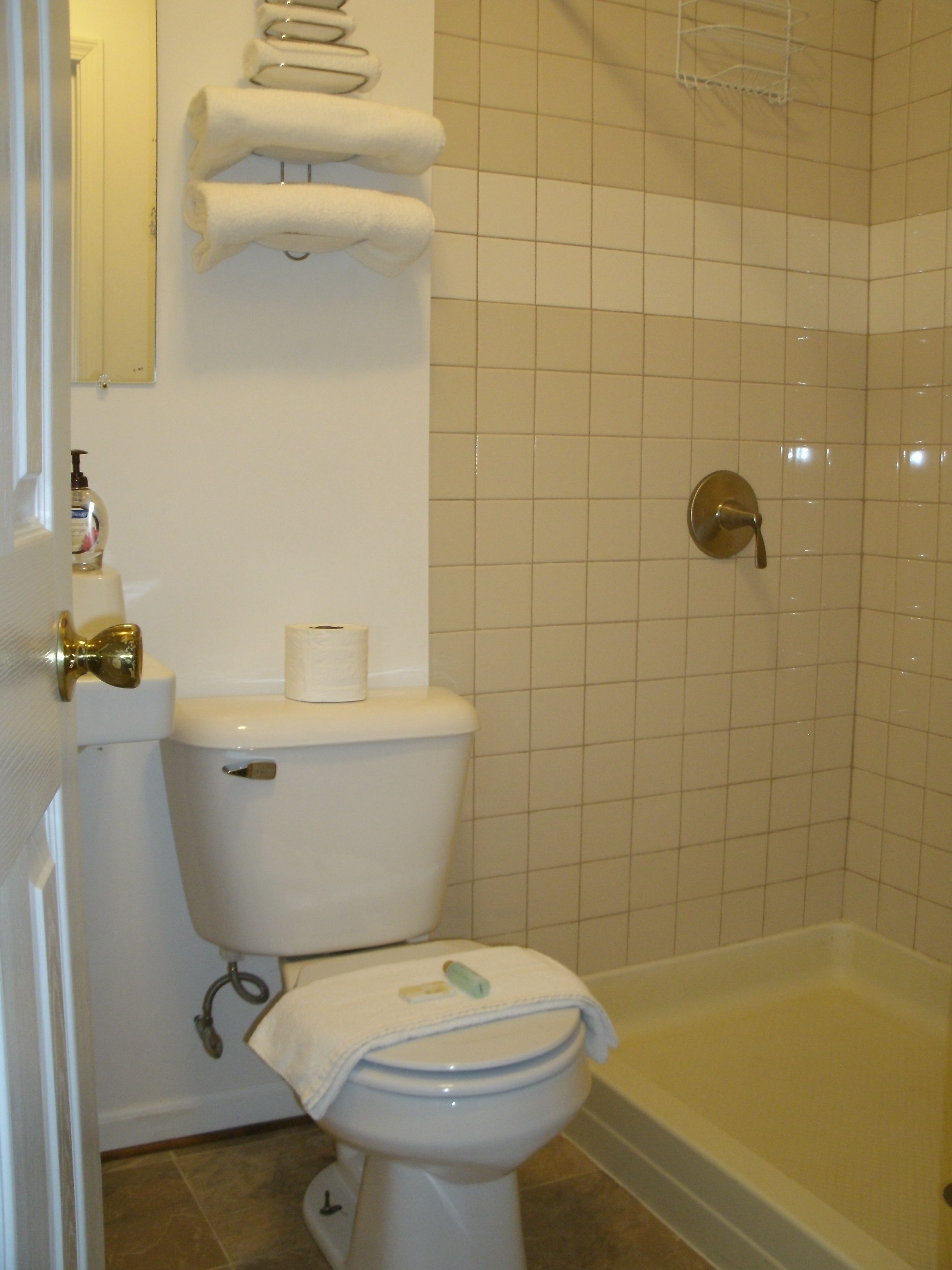 A bathroom with a toilet, a bathtub, and a towel rack.