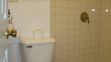 A bathroom with a toilet, a bathtub, and a towel rack.