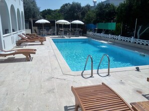 Piscine extérieure, parasols de plage, chaises longues