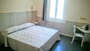 A bedroom with a bed, a desk, and a window. - Hotel Cantore (Genoa)
