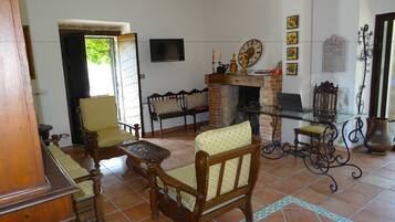 A living room with a fireplace, wooden furniture, and a television.