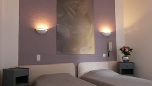 A hotel room with two beds, a wall-mounted painting, and two bedside lamps. - Hôtel An Ti Gwenn (Carnac)