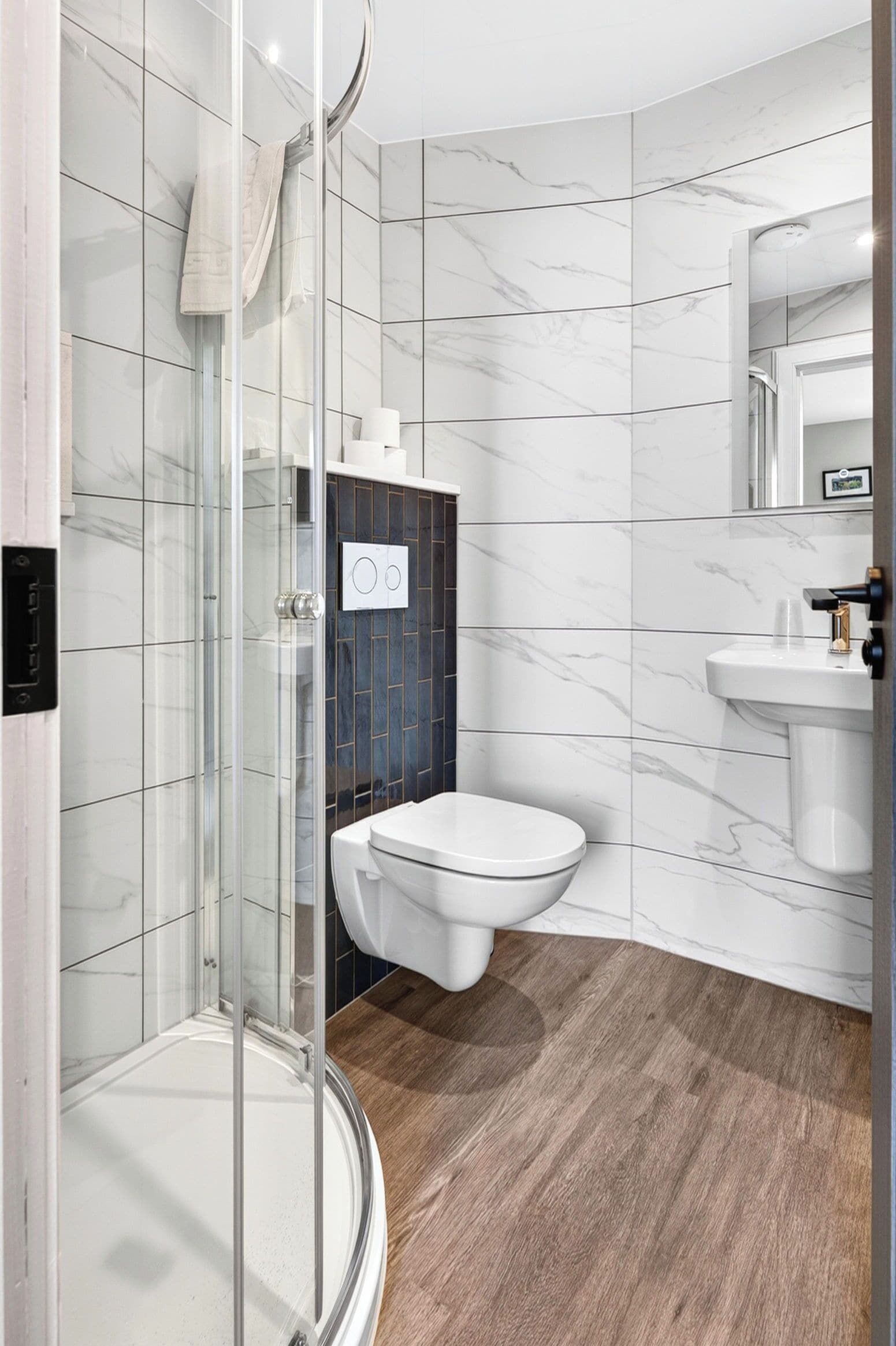 Une salle de bain moderne avec une douche à parois de verre, des toilettes et un lavabo.