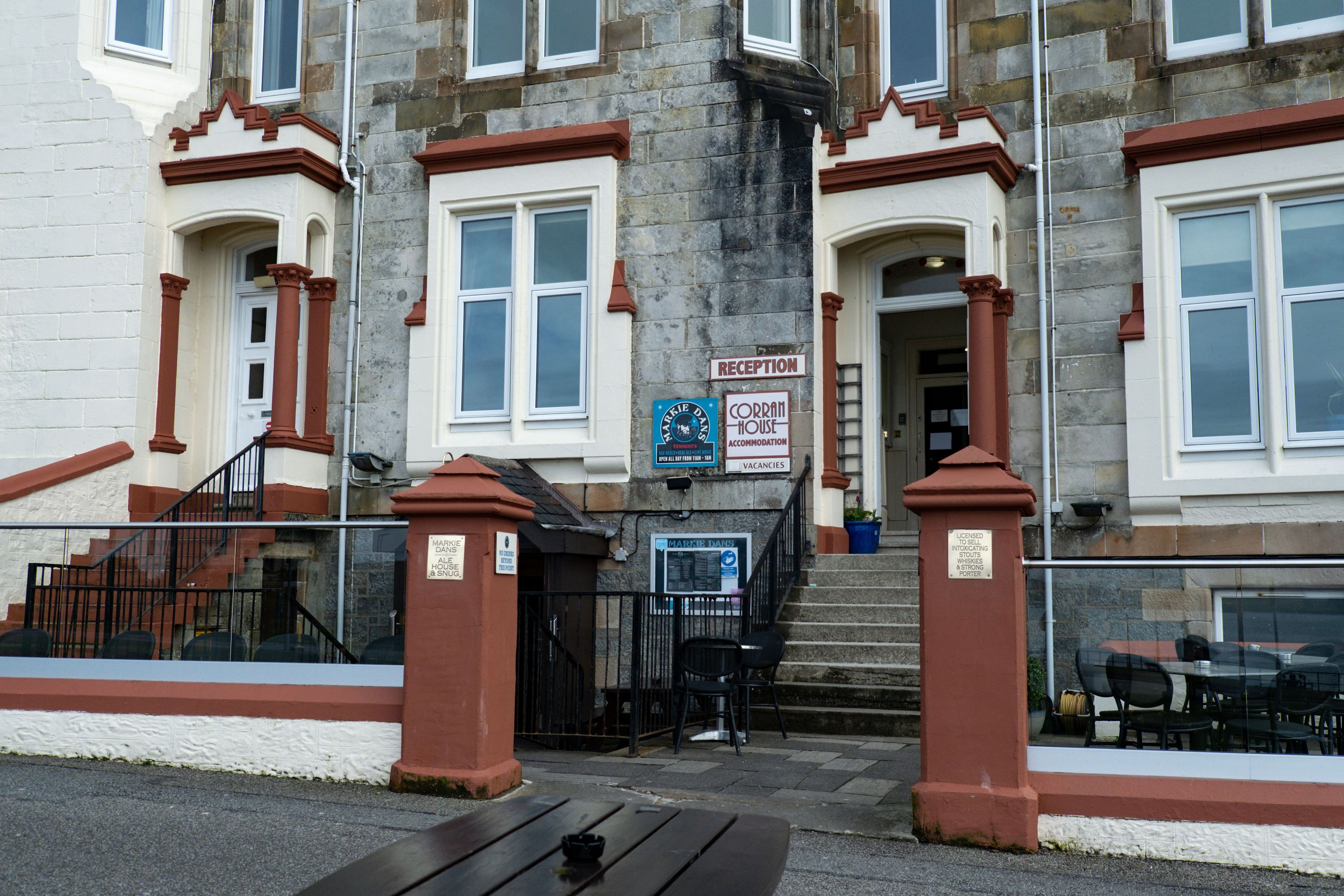 A building with a reception sign, a staircase leading to the entrance, and a sign indicating vacancies.