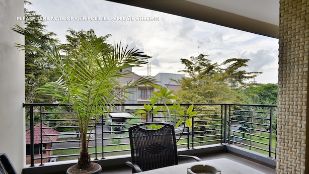 A balcony with a potted plant, a chair, and a table. - Casa Vanda Guesthouse (South Tangerang)