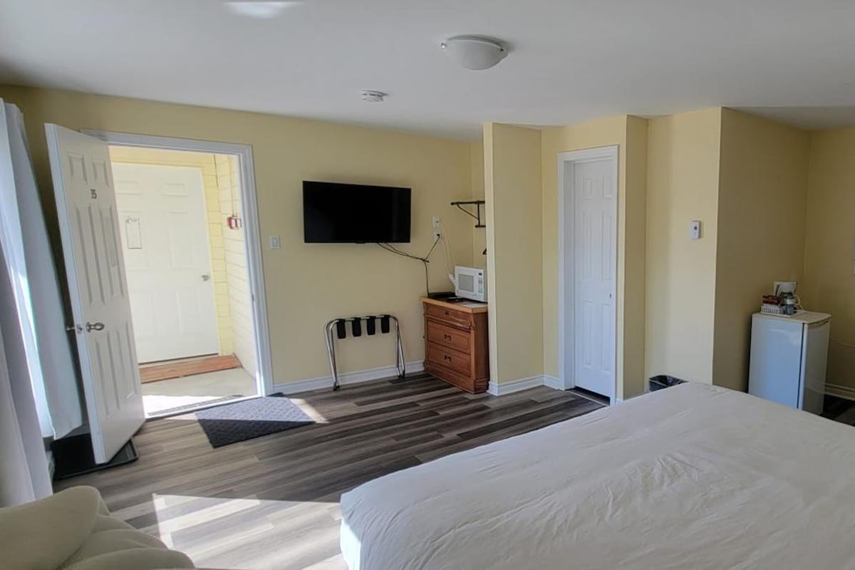 Une chambre d’hôtel équipée d’un lit, d’un bureau, d’une chaise, d’une télévision et d’un appareil de climatisation.