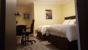 A hotel room with a bed, a desk, and a chair. - North Shore Wayside Inn (Blind River)