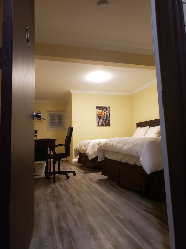 A hotel room with a bed, a desk, and a chair. - North Shore Wayside Inn (Blind River)