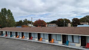 A motel with a row of rooms, each with a door number and a window. - North Shore Wayside Inn (Blind River)