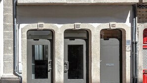Three arched doorways with numbers 342, 343, and 340, leading to a building with a stone facade. - BO - Almada 340 (Porto)