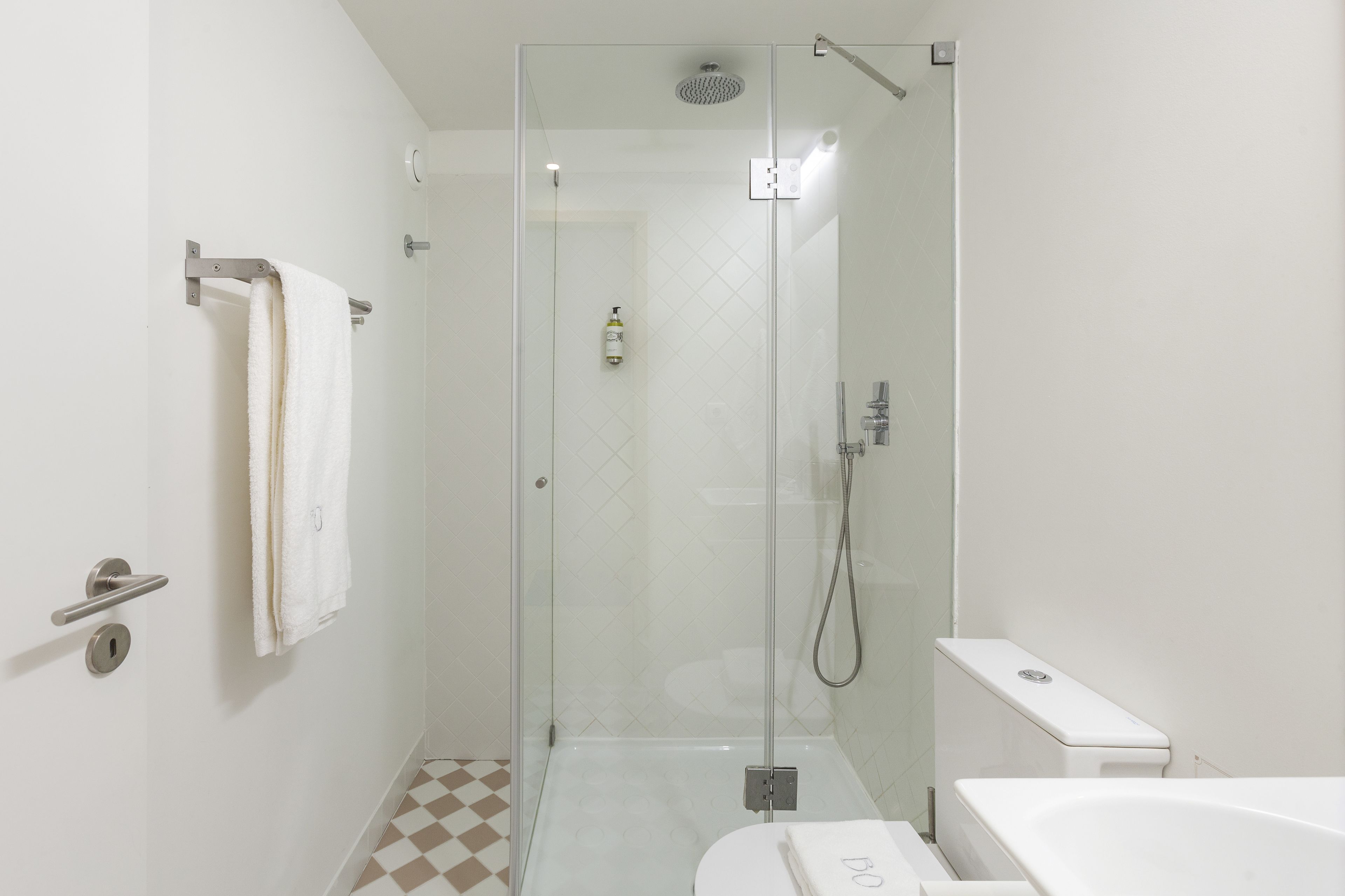 A modern bathroom with a glass-enclosed shower, a toilet, and a bathtub.