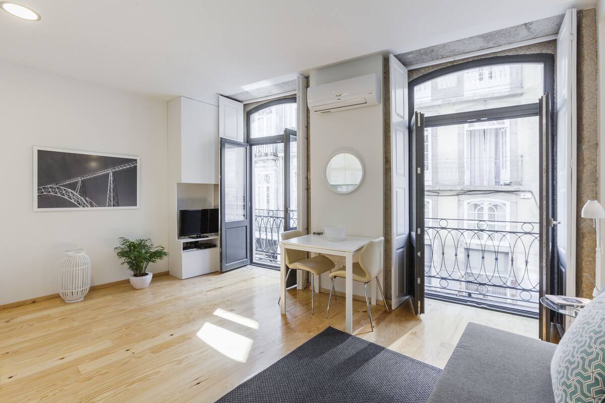 Una sala de estar moderna con comedor, ventanas amplias y vistas a la ciudad.
