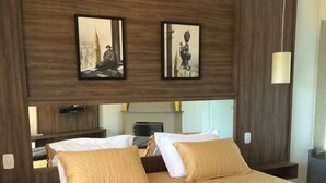 A hotel room with a large bed, two bedside tables, a nightstand, a mirror, and two framed pictures on the wall. - Hotel Fazenda Santa Maria (Serra Negra)