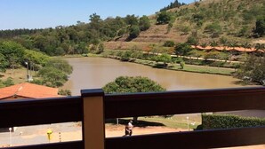 A view of a river with a bridge, surrounded by greenery and hills. - Hotel Fazenda Santa Maria (Serra Negra)