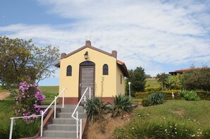 Une petite église surmontée d’une croix, dotée d’un clocher et d’un escalier menant à l’entrée.