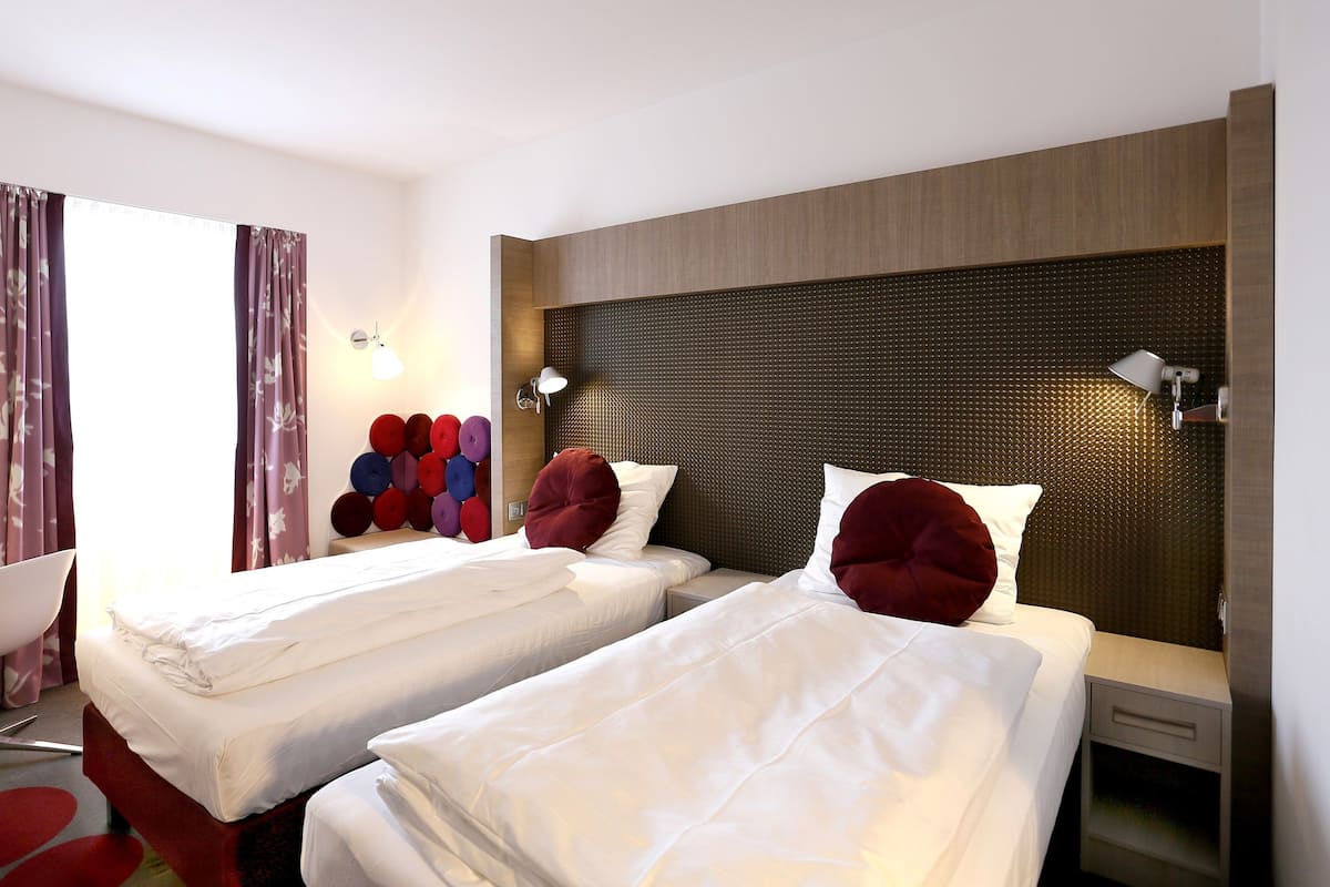 Una habitación de hotel con dos camas, un escritorio y una silla.
