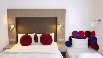 A hotel room with a large bed, two bedside tables, a wall-mounted lamp, and a headboard with a textured pattern.