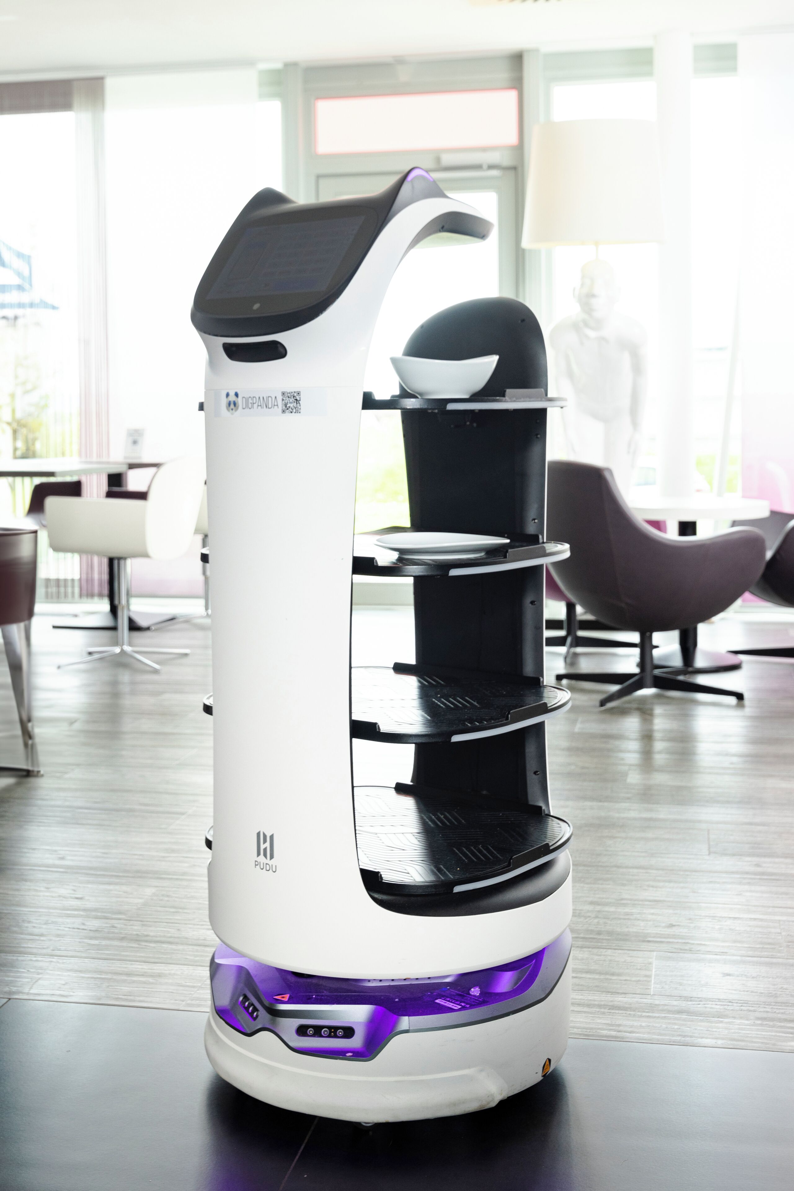 Ein weißer und schwarzer Elektroscooter mit Digitalanzeige, Ablagefläche und violetter Beleuchtung.