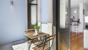 A modern kitchen with white cabinets and a microwave. - BO - Bolhão Apartments (Porto)