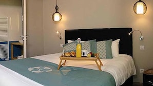 A neatly made bed with a tray of breakfast items, a bedside lamp, and a wall-mounted light fixture. - Auberge de l'Abbaye (Thiron-Gardais)