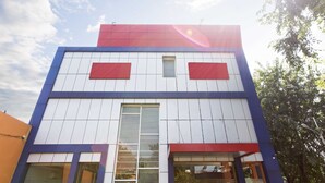 Un bâtiment moderne doté d’un toit plat, de deux fenêtres apparentes et d’une porte.