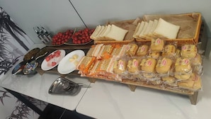 A buffet table with various food items including bread, cheese, and fruits. - Guang Dong Hotel (Guangzhou)
