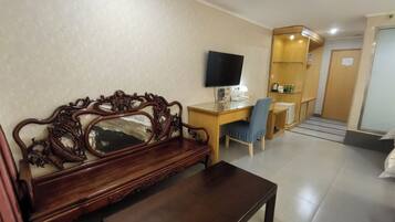 Deluxe Triple Room | Living area | 25-inch LCD TV with cable channels, TV