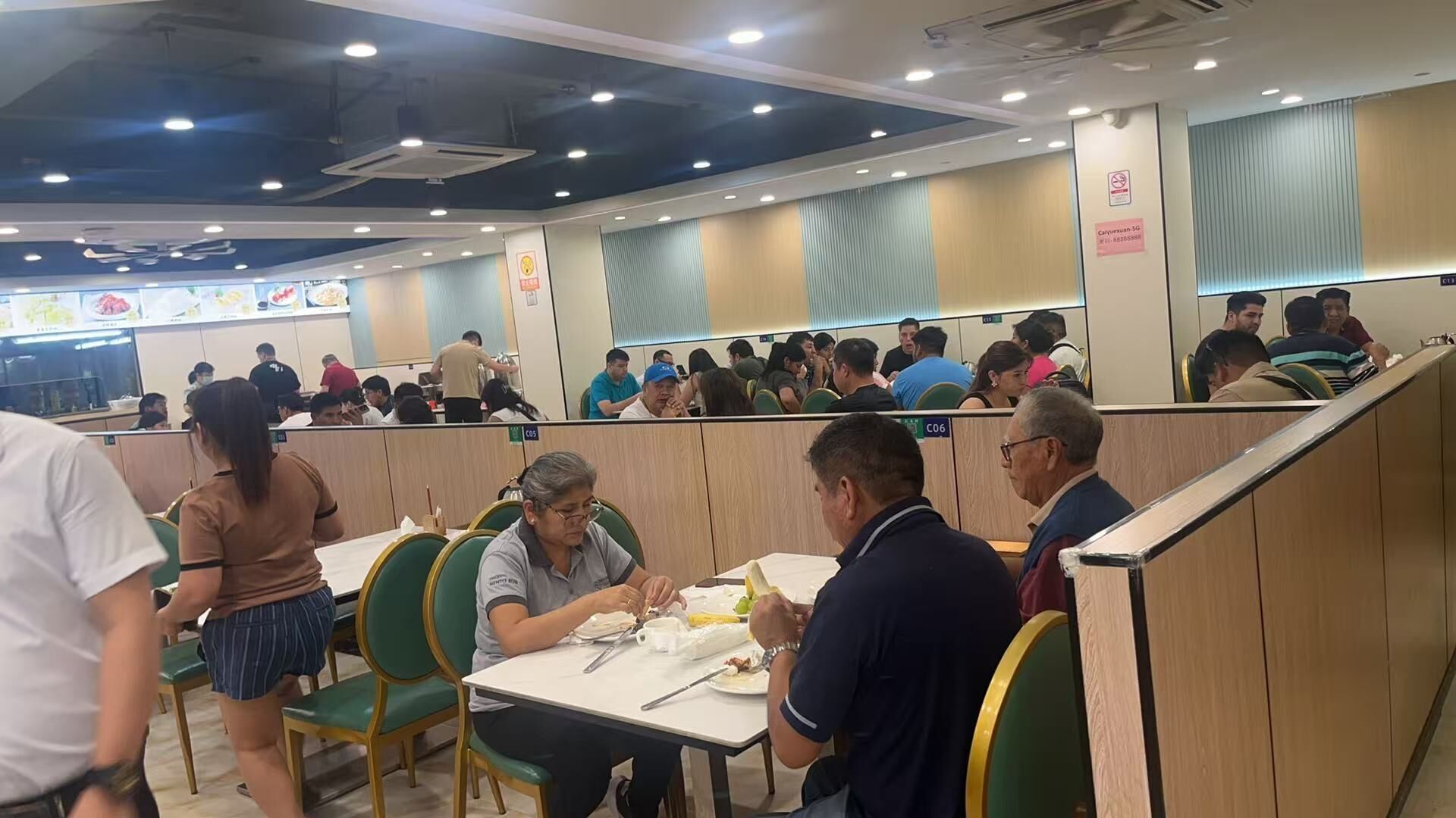 Un restaurante con cabinas, mesas y una barra.