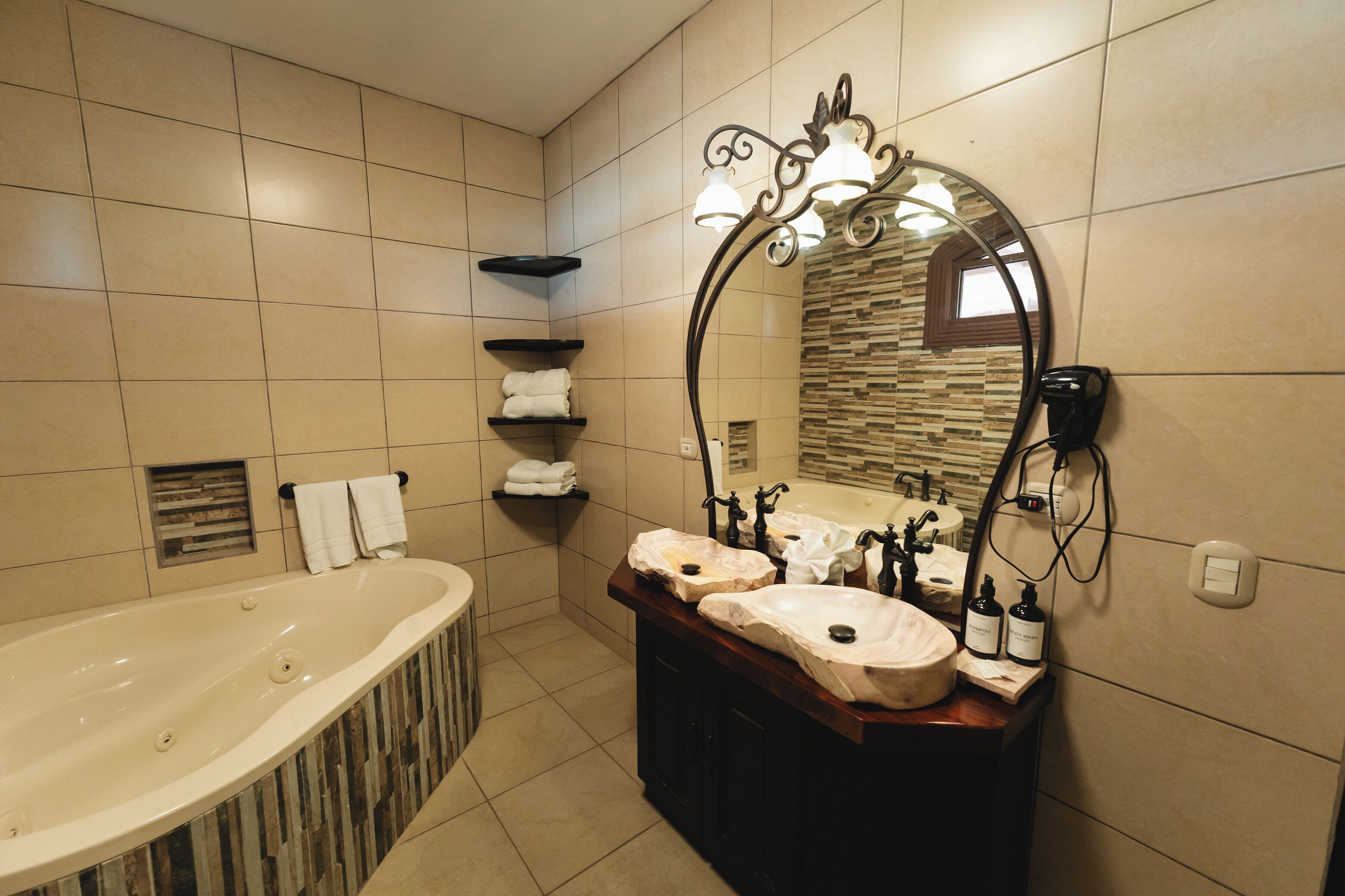 A modern bathroom with a freestanding bathtub, a vanity with two sinks, and a large mirror.