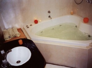 A bathroom with a bathtub, a sink, and towels.