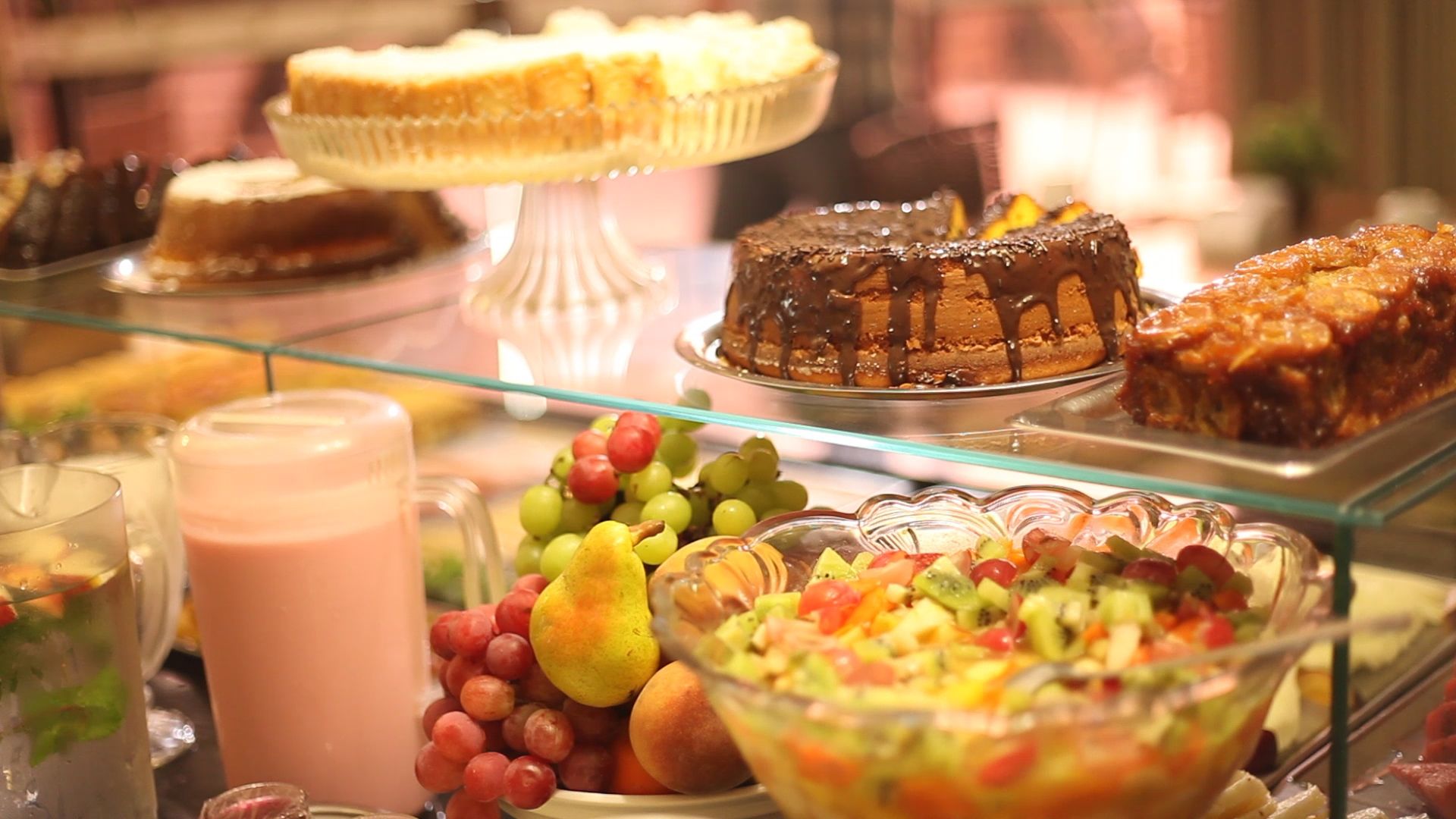 A buffet with various desserts, fruits, and a fruit salad.