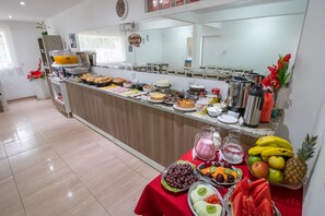 A breakfast buffet with various food items and beverages. - Pousada Vovó Dilma (Penha)