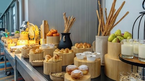 A buffet with various pastries, fruits, and beverages arranged on wooden stands. - Aloft by Marriott Riyadh (Riyadh)