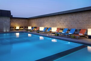 A swimming pool with lounge chairs and a stone wall.