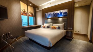 A modern hotel room with a large bed, a view of the city through a window, a desk, and a chair. - Aloft by Marriott Riyadh (Riyadh)