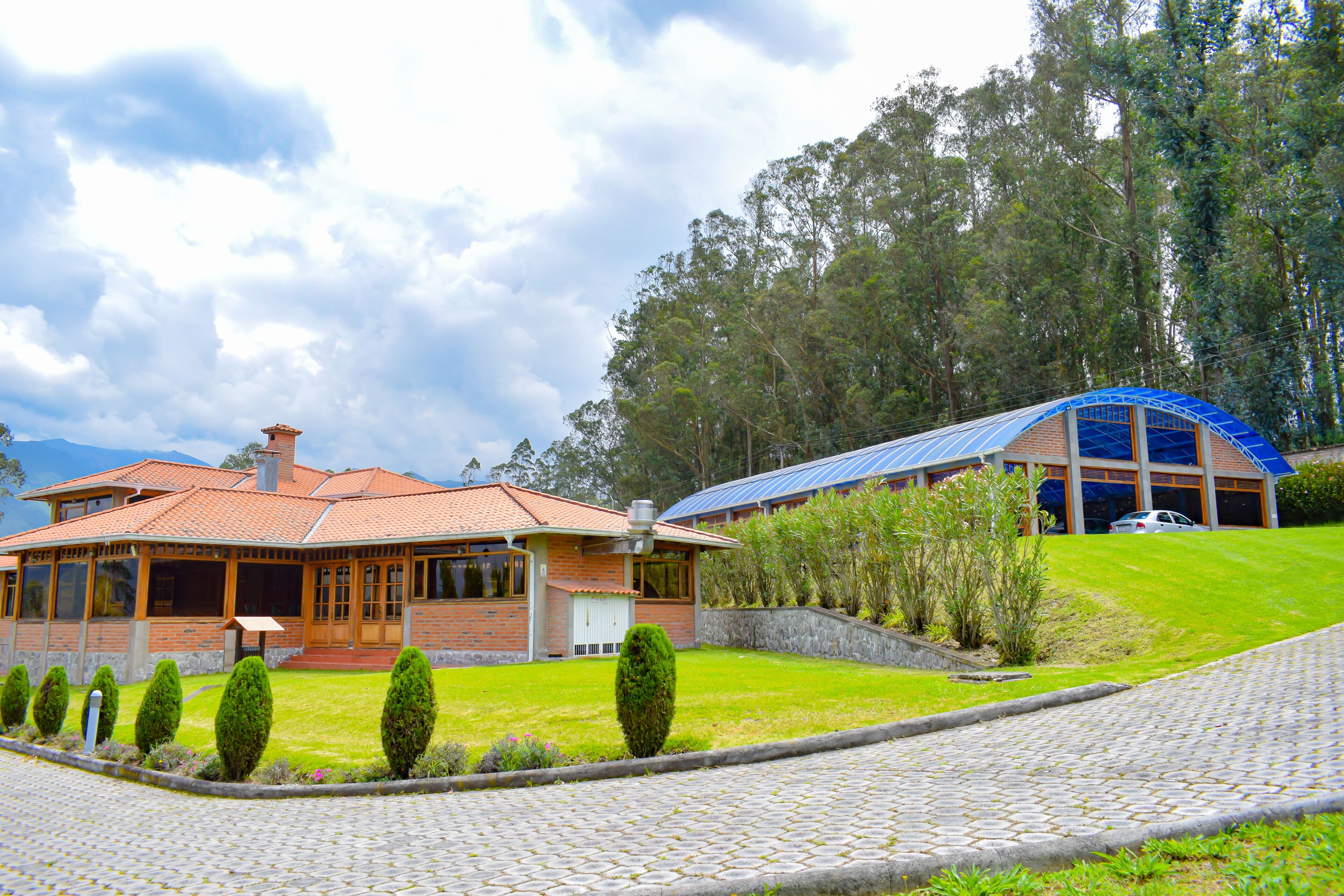 A two-story house with a brick facade, a tiled roof, and a covered porch.