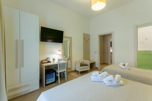 A hotel room with a bed, a desk with a chair, a television, and a wardrobe. - B&B Cairoli (Messina)