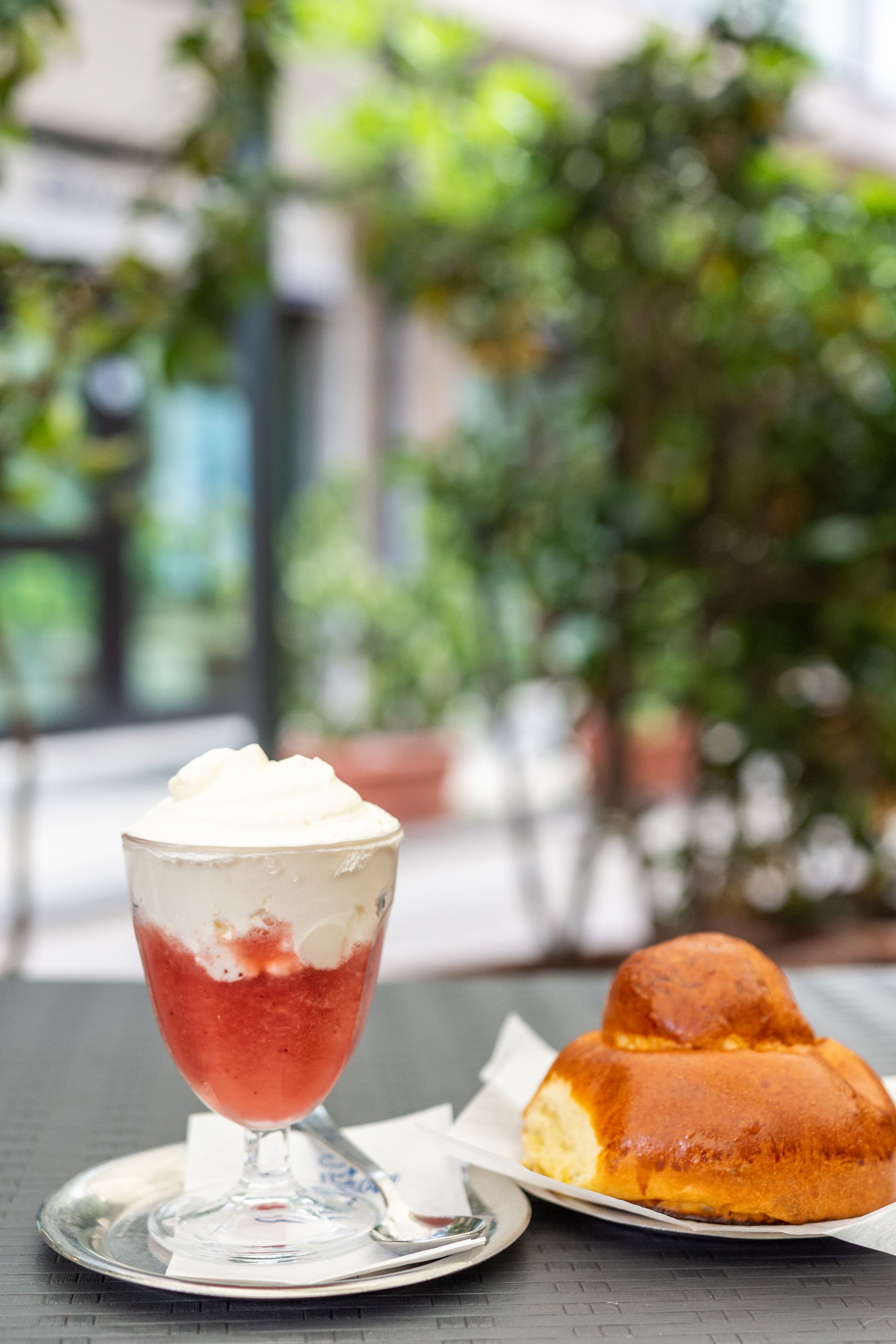 Sobremesa com chantilly e um pastel sobre a mesa.