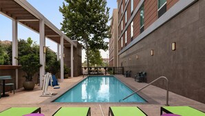 A pool area with lounge chairs and a diving board. - Home2 Suites by Hilton Houston Energy Corridor (Houston)