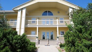 Un bâtiment à deux étages doté d’une façade symétrique, d’une entrée centrale avec une double porte et d’un balcon à l’étage supérieur.