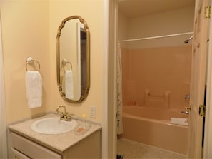 A bathroom with a sink, mirror, towel rack, and a bathtub. - The Rukmapura Park Hotel (Fairfield)