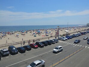 Une plage avec un parking et une route.
