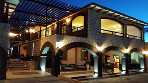 A two-story building with stone arches and a covered patio area. - Hotel Villa Bernal (Ezequiel Montes)
