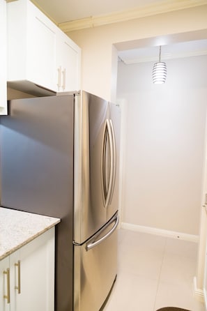 Apartamento superior, 1 quarto, suíte | Cozinha privada | Geladeira grande, micro-ondas, fogão, cooktop
