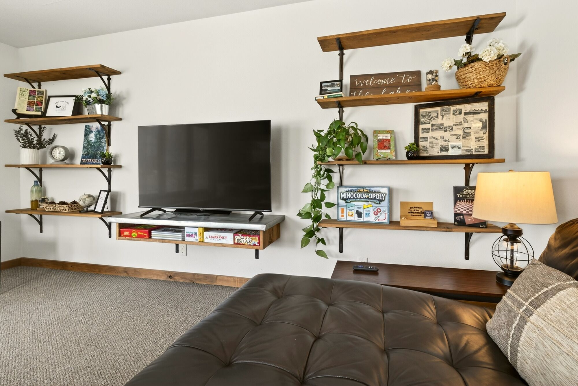 Een woonkamer met een flatscreen televisie, boekenkasten, een salontafel en een bank.