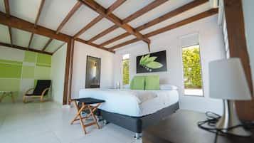 A modern bedroom with a bed, a desk, a chair, and a window.